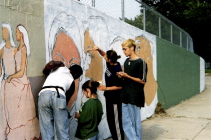 Four teenagers in 90's fashion painting a mural on an outdoor wall