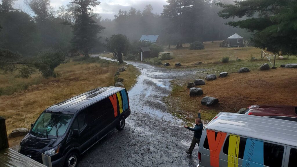 Two YIA vans in a rural parking lot on a misty day